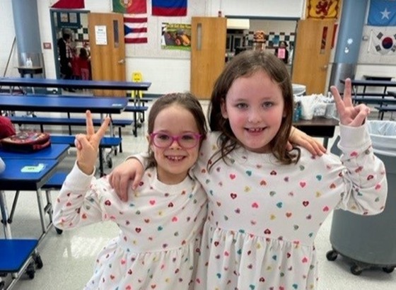 Two girls wearing matching heart dresses