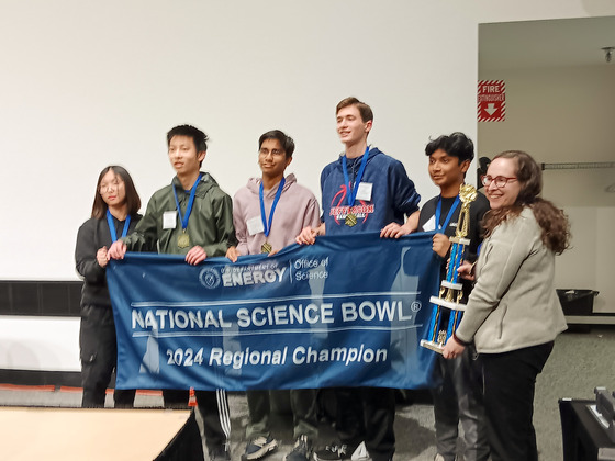 Science Bowl team holding the Regional Championship banner and trophy after winning the Virginia Regional Science Bowl