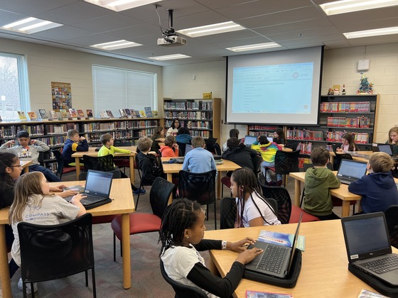 An image of a fourth grade class working on laptops in the Clermont library.