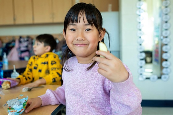 student holds an apple slice