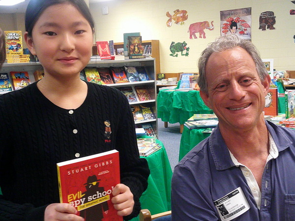 Picture of a student meeting and having her book signed by the popular Author Stuart Gibbs who visited our school last Thursday.