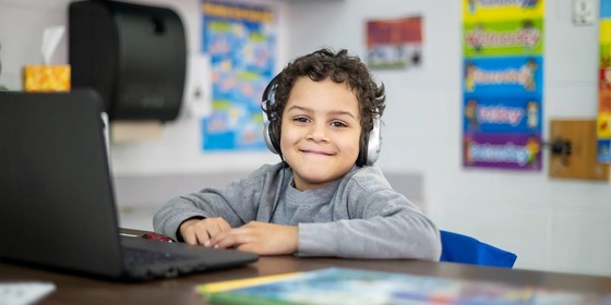 student smiling with headphones