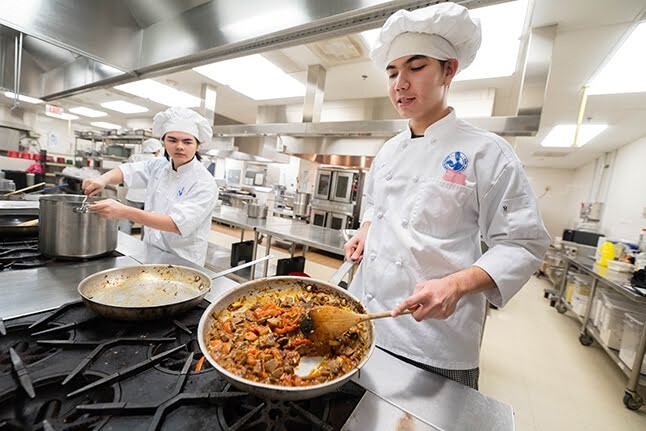 student cooking over a stove