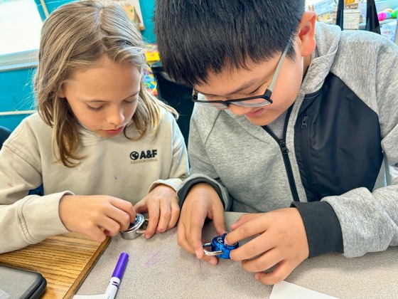 Two sixth grade students practice opening combination locks in preparation for middle school.
