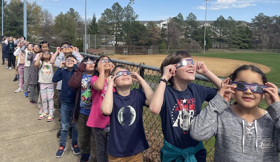 Students watching the solar eclipse wearing safety glasses