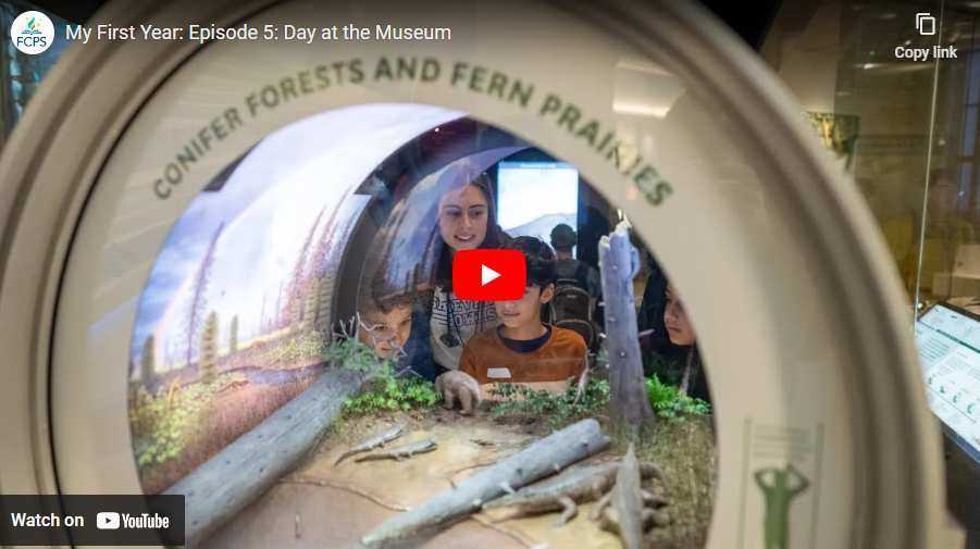 Teacher with students viewing museum display of conifer forests an fern prairies