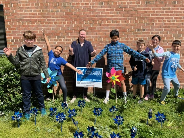 students with pinwheels in front of school