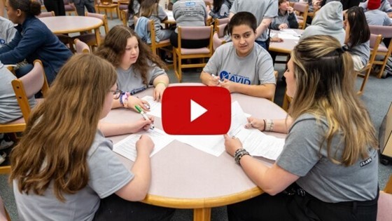 Students sitting around table with Clark Construction employee