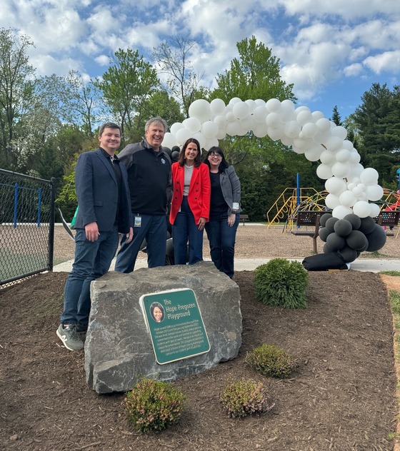 Assistant Principal, Principal, Region 5 Assistant Superintendent, and Delegate Cohen standing in front of memorial plaque