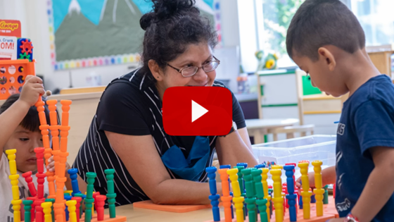 Teacher working with student at table