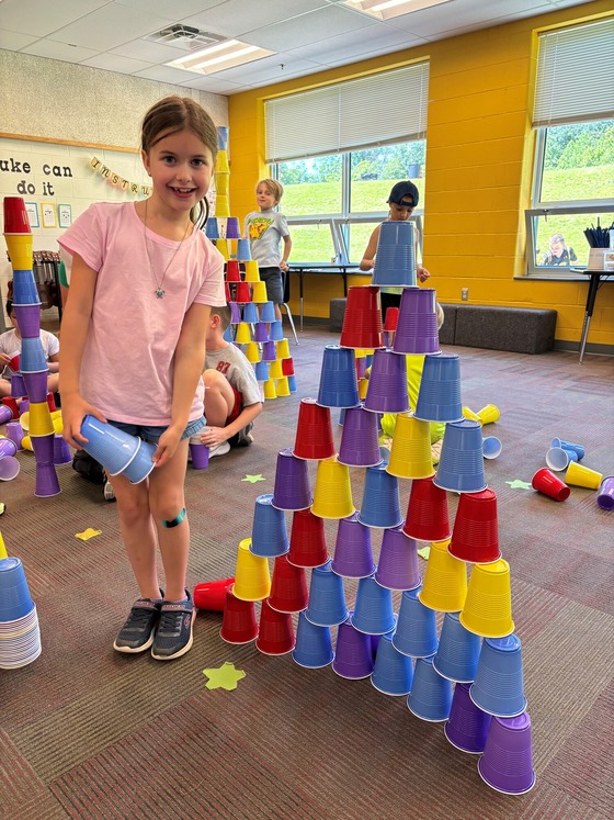 Students stack cups during an indoor field day activity. 
