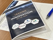 Leading for Tomorrow's Innovation printed program on a table where c-suite executives are discussing K-12 education.