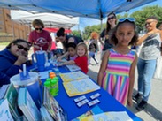 Summer Extravaganza tent with students working on art.