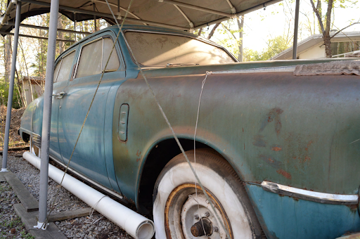Teal and slightly rusty 1948 Studebaker Land Cruiser waiting to be donated.