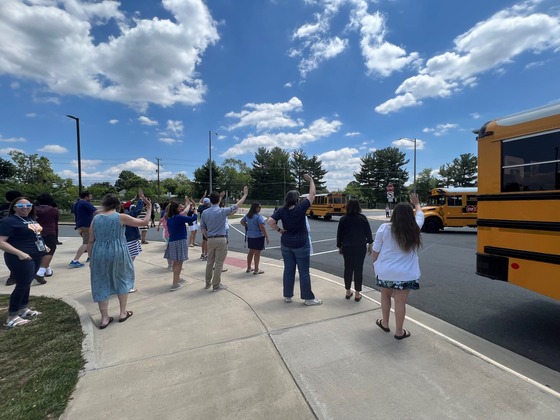 Staff waving goodbye to school buses
