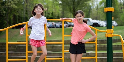 Students standing on playground equipment