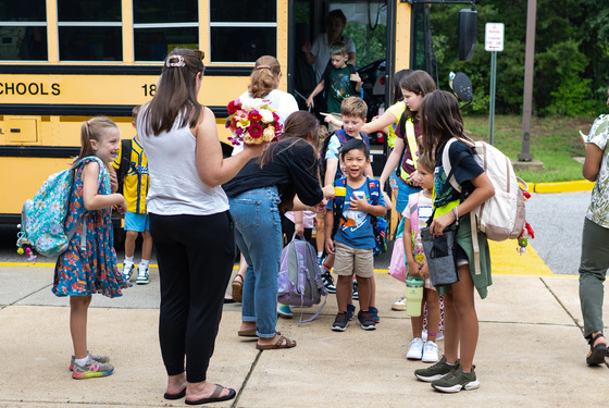 Students get off a bus at a school