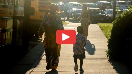 Screen capture showing child and parent walking to school in the sunrise