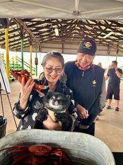 two people smiling for a photo while holding their dog