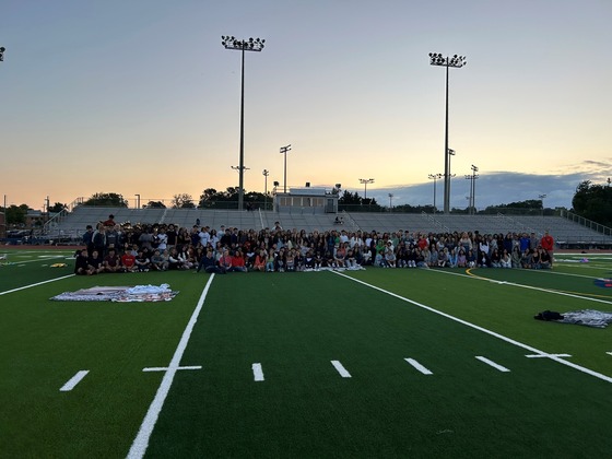 Students on the football field at sunrise