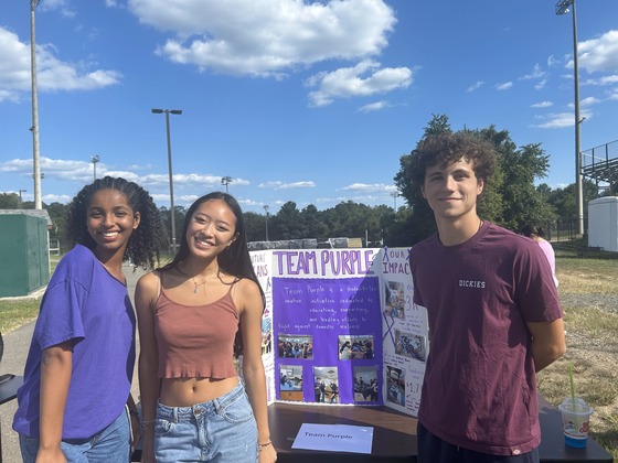 Students standing outside on either side of a poster board