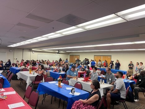 Adults sitting at tables in a large room