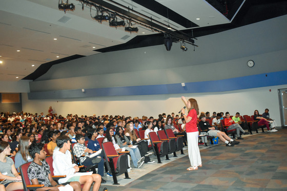 Dr. Bonitatibus speaks with the new students in the auditorium 