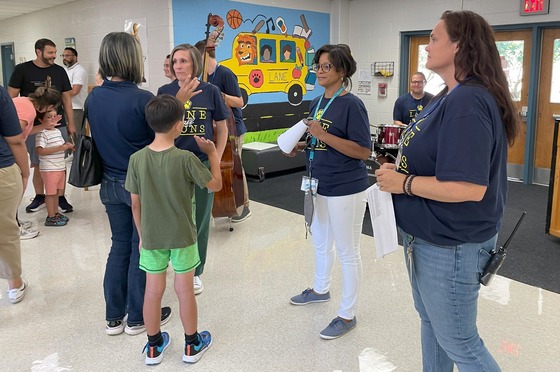 Staff members welcoming families to Open House