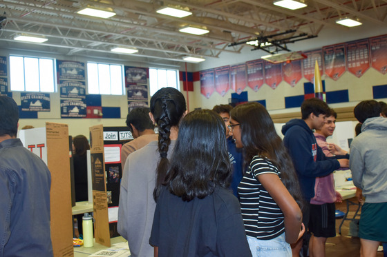 Students gathered around a booth at eighth period activity fair