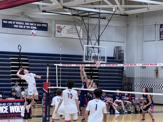 boys volleyball player jumping to hit the ball