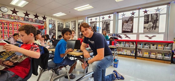 teacher smiles next to student