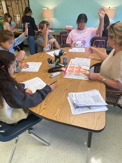 Students working at table with Mrs. Trimble