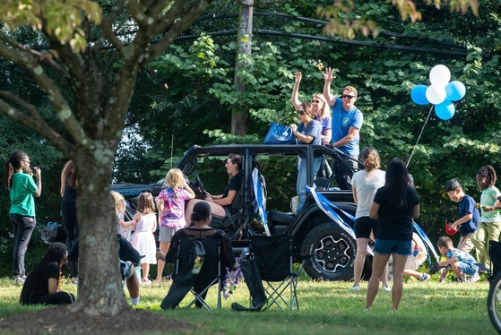 principals wave from the back of a jeep during a homecoming parade