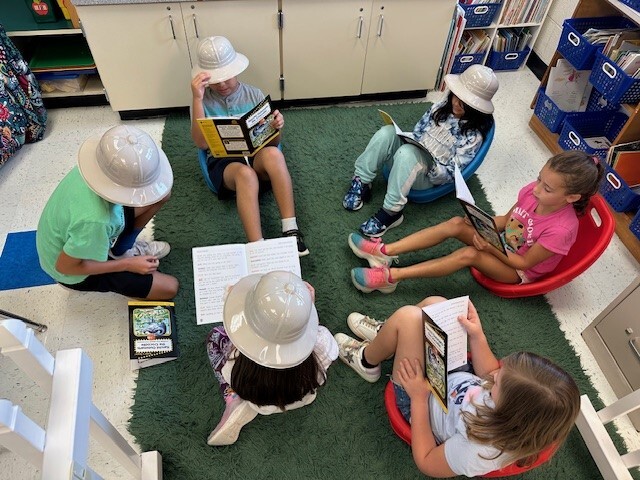 second grade students reading about plants and animals