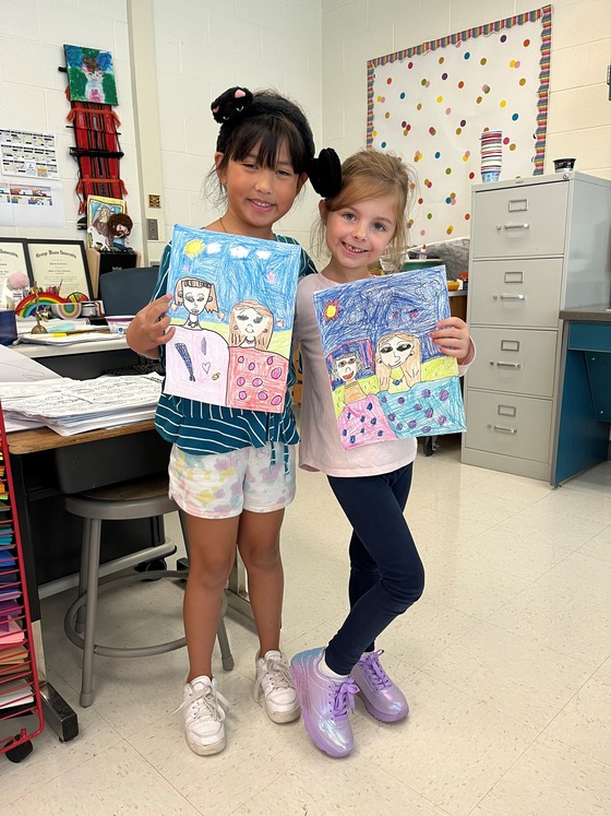 Two Clermont students pose with their self-portraits.