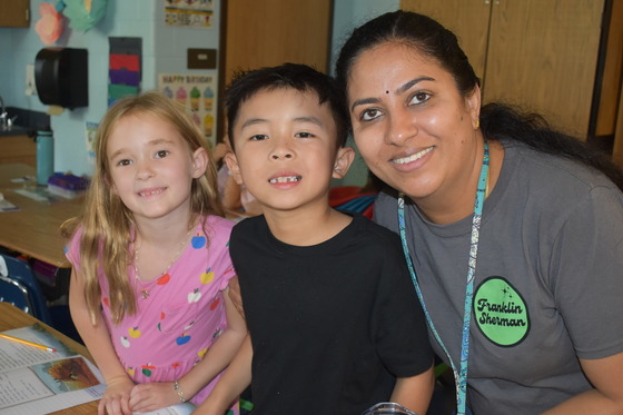 Picture of students and staff smiling in the classroom.