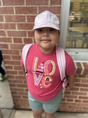 A student stands in a pink hat for hat day 