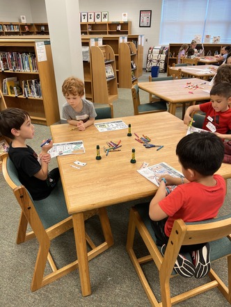 Students sit around a table for crafternoons afterschool club 