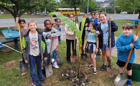 5th graders in the garden around a tree they just planted