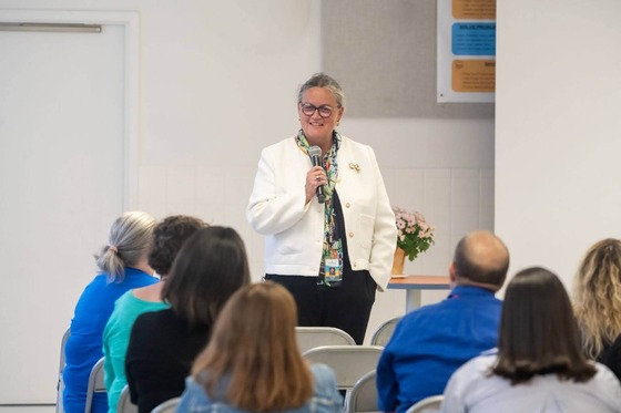 Dr. Reid speaks into a microphone to an audience