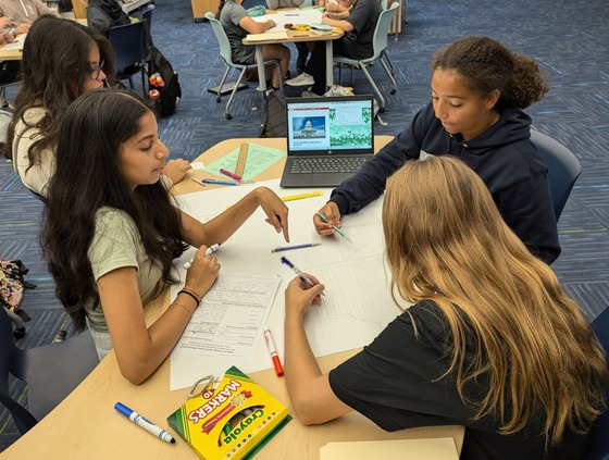 Students in Mrs. DeRusso’s class work in a group on a poster of a famous Hispanic American.