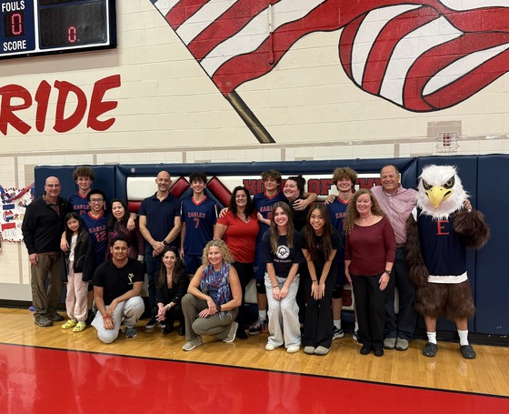 students and parents standing by the wall in the gym