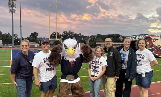 adults standing with the Edison Eagle