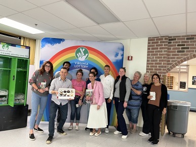 group of people standing in front of a rainbow backdrop