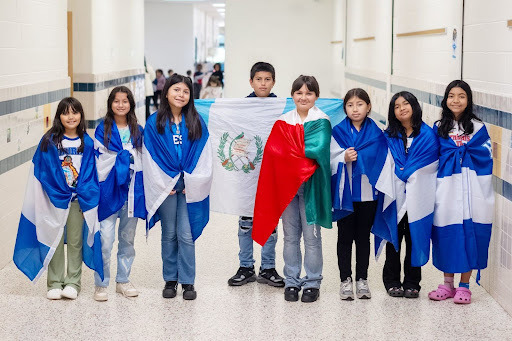 children smiling with flags wrapped around them