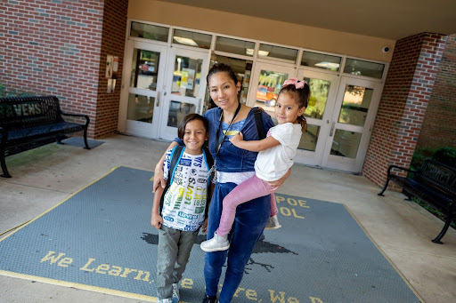 mother smiles with her two children