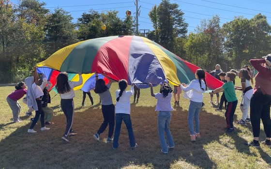 Students bouncing balls on a parachute at Field Day