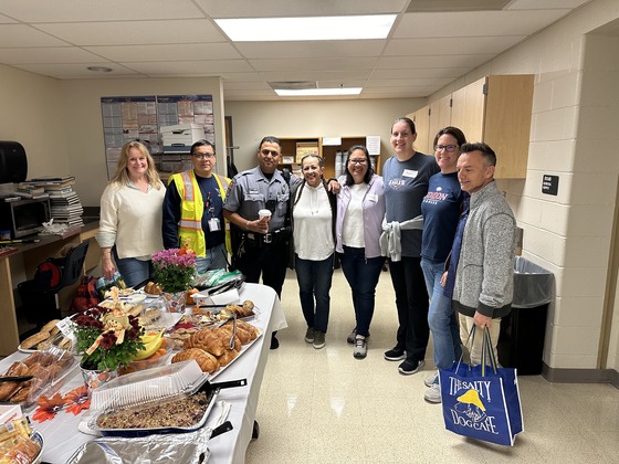 Adults standing by a table with food