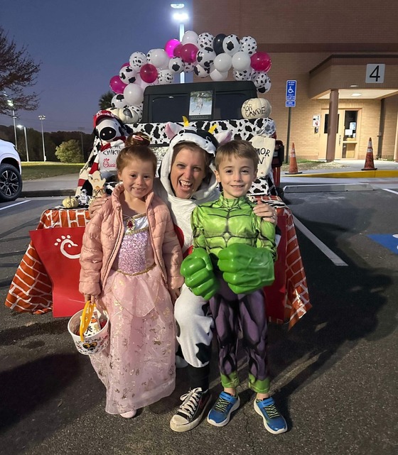 Teacher dressed as a Chick-fil-A cow with two students in costumes