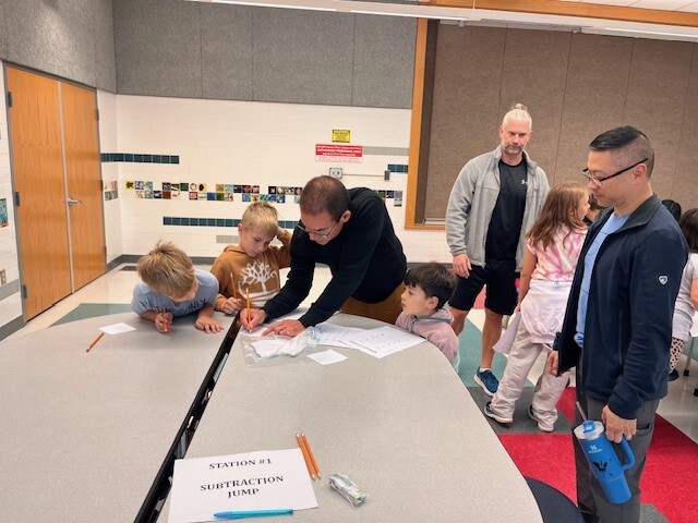 Teacher, Mr. Ramirez, leads engaging math games with students on Math Night.